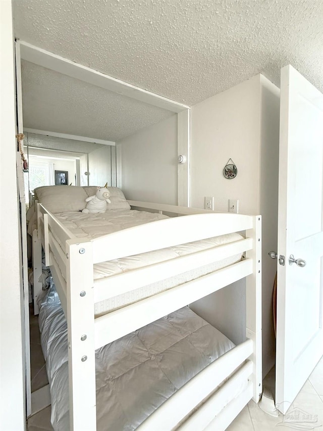 tiled bedroom with a textured ceiling