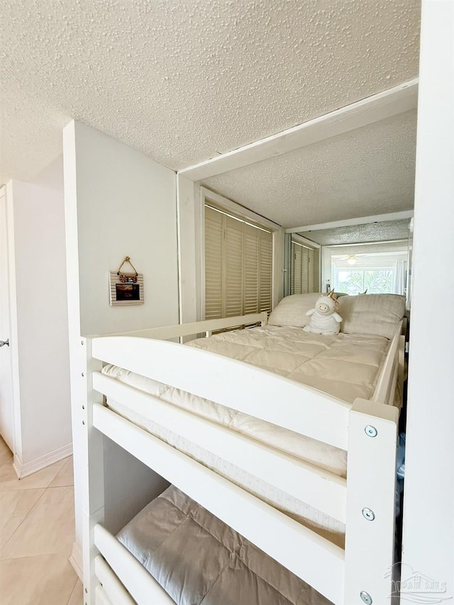 bedroom with tile patterned floors and a textured ceiling