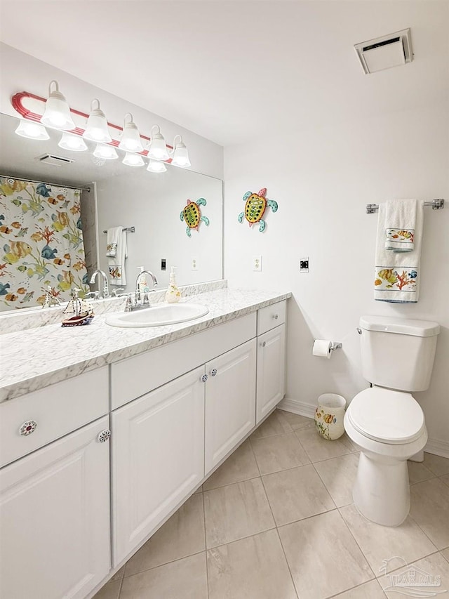 bathroom with vanity, toilet, baseboards, tile patterned floors, and visible vents