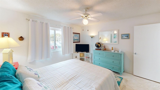 bedroom featuring light tile patterned flooring, a textured ceiling, and a ceiling fan