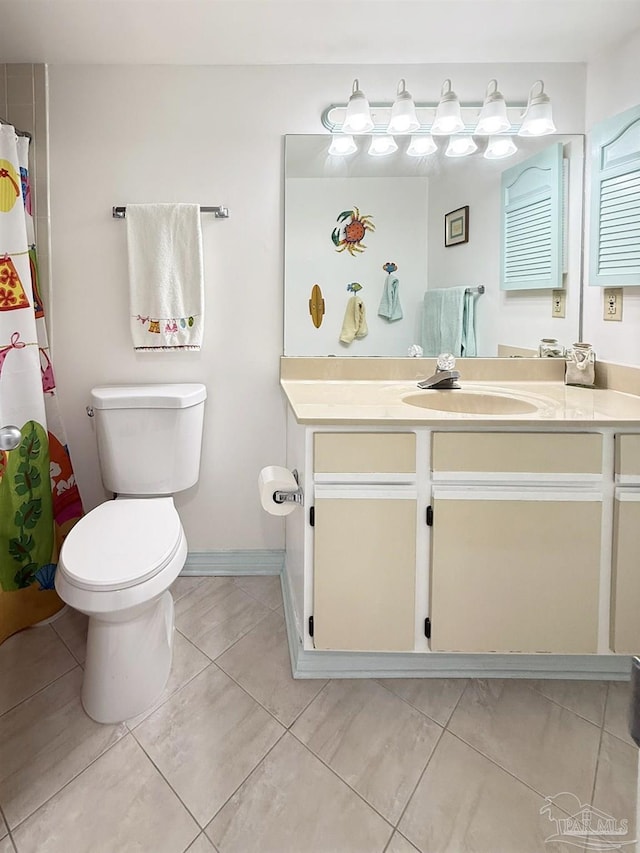 full bath featuring baseboards, toilet, vanity, and tile patterned floors