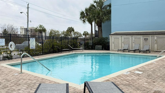 pool featuring fence and a patio area