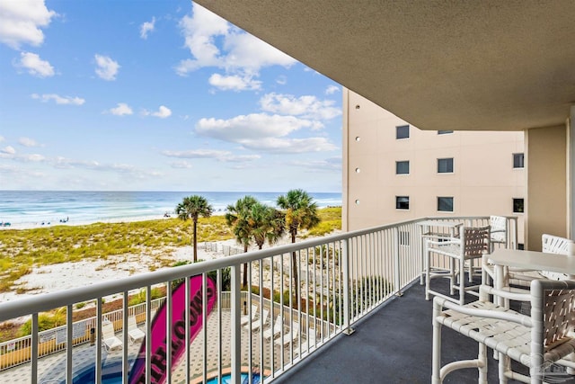 balcony featuring a beach view and a water view