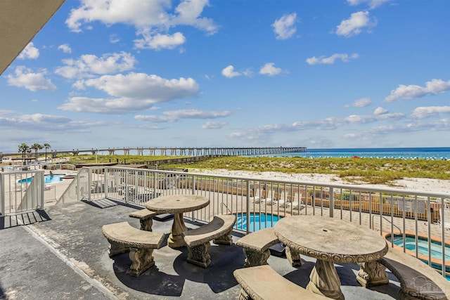 view of patio with a water view and a fenced in pool