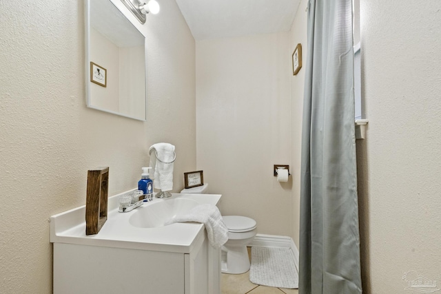 bathroom with tile patterned flooring, vanity, and toilet