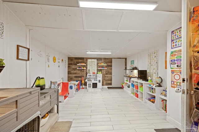 recreation room with wood walls