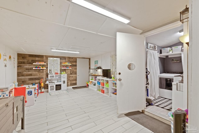 interior space featuring lofted ceiling and wooden walls