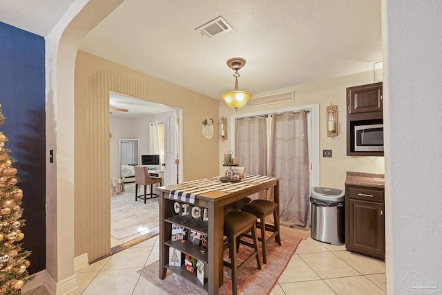 tiled dining room with a textured ceiling