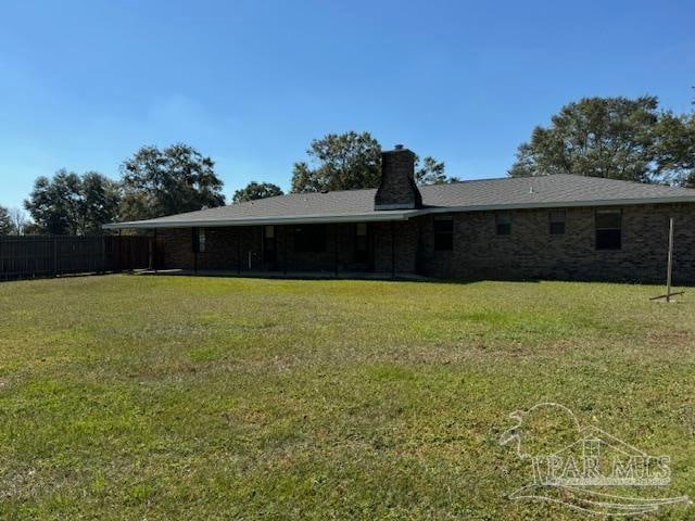 rear view of house featuring a yard