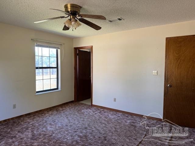 spare room featuring a textured ceiling, carpet floors, and ceiling fan