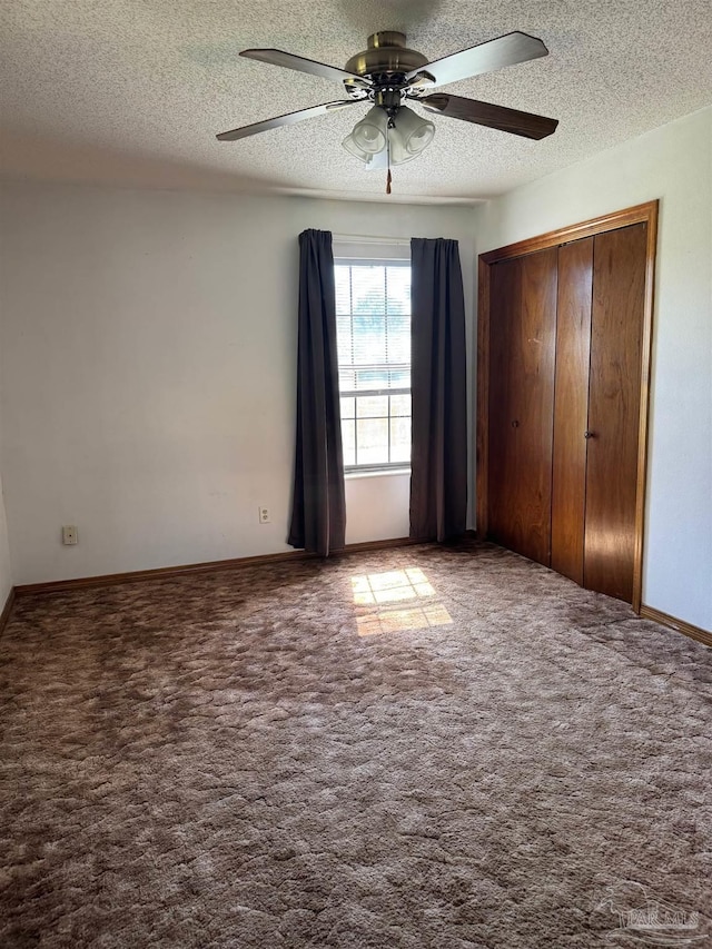 unfurnished bedroom featuring ceiling fan, a closet, carpet floors, and a textured ceiling