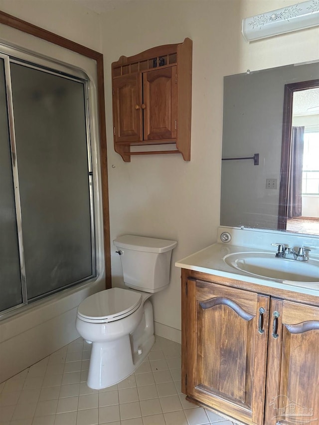 full bathroom with a wall mounted air conditioner, combined bath / shower with glass door, vanity, tile patterned flooring, and toilet