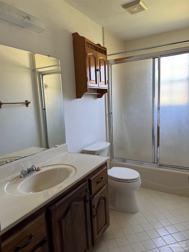 full bathroom with shower / bath combination with glass door, vanity, tile patterned floors, and toilet