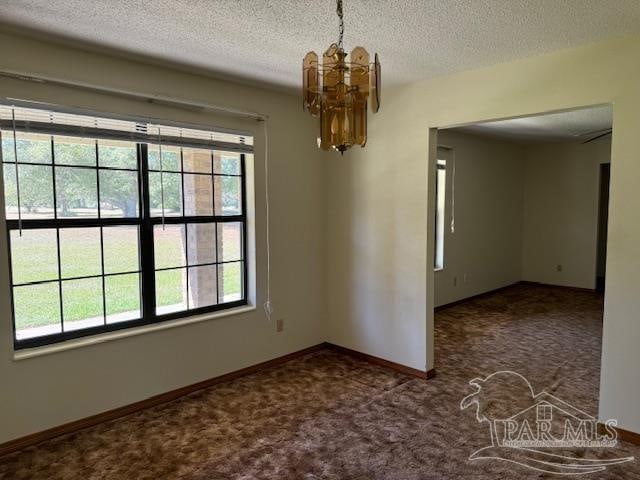 unfurnished dining area featuring a textured ceiling, carpet floors, and a notable chandelier