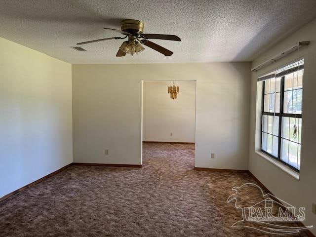 carpeted empty room with a textured ceiling, ceiling fan, and a healthy amount of sunlight