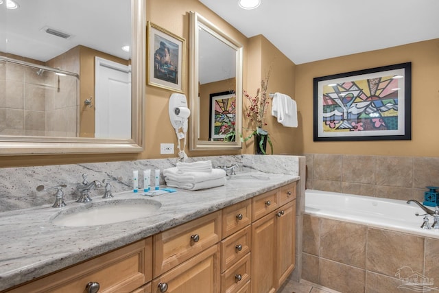 bathroom featuring double vanity, visible vents, a garden tub, and a sink
