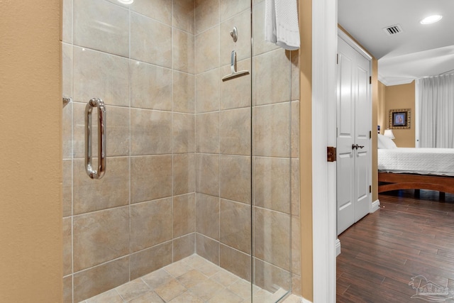ensuite bathroom featuring recessed lighting, wood finished floors, visible vents, ensuite bath, and tiled shower