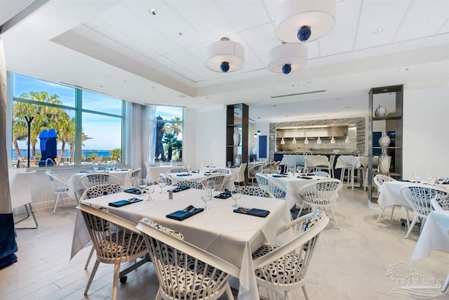 dining area with a wealth of natural light and a tray ceiling