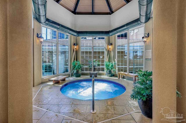 view of swimming pool with glass enclosure, a gazebo, and a patio
