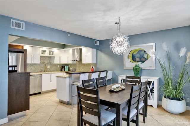 dining room with light tile patterned flooring, sink, and an inviting chandelier