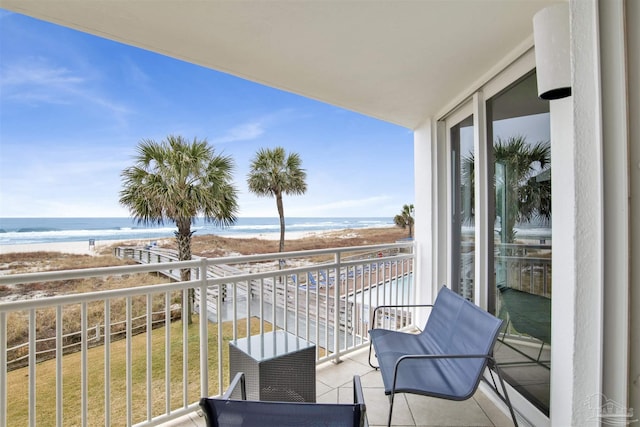 balcony featuring a water view and a view of the beach