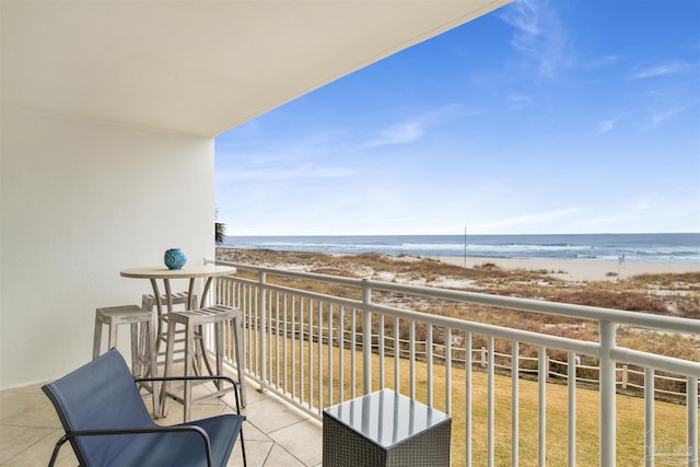 balcony featuring a water view and a beach view