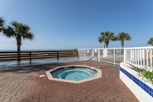 view of pool featuring a community hot tub and a water view