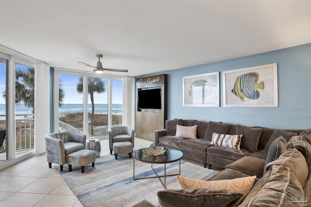 living room featuring ceiling fan, a wall of windows, and light tile patterned floors