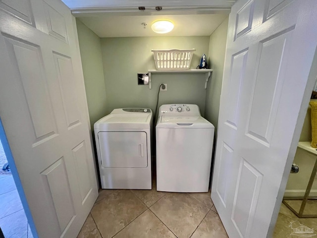 laundry room with light tile patterned floors and washer and clothes dryer