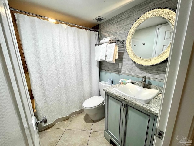 bathroom with tile patterned flooring, vanity, and toilet