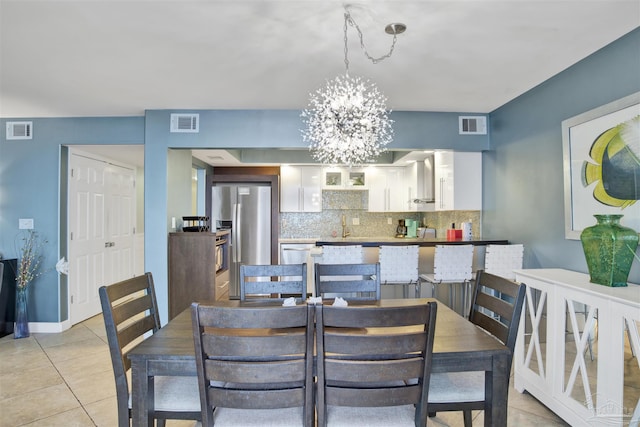 dining space featuring sink, light tile patterned floors, and a chandelier