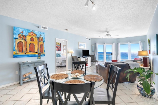 dining room featuring ceiling fan, a textured ceiling, and light tile patterned flooring