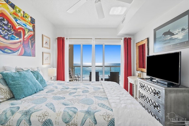 bedroom featuring a textured ceiling, access to exterior, and ceiling fan