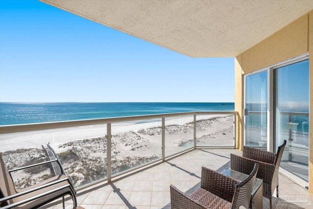 balcony with a water view and a beach view