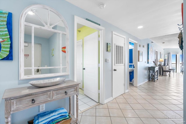 hall featuring light tile patterned floors