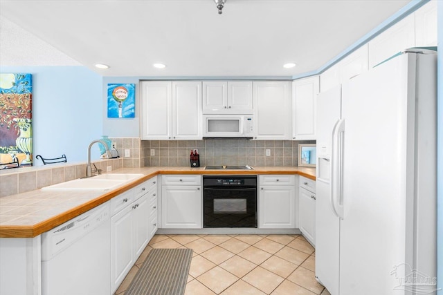 kitchen featuring sink, black appliances, white cabinetry, and tile counters