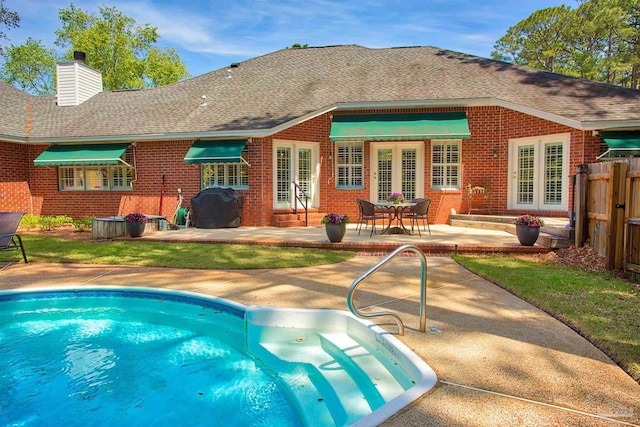 4200 Madura Rd, Gulf Breeze, FL 32563 - rear view of property featuring roof with shingles, a chimney, a patio area, and brick siding