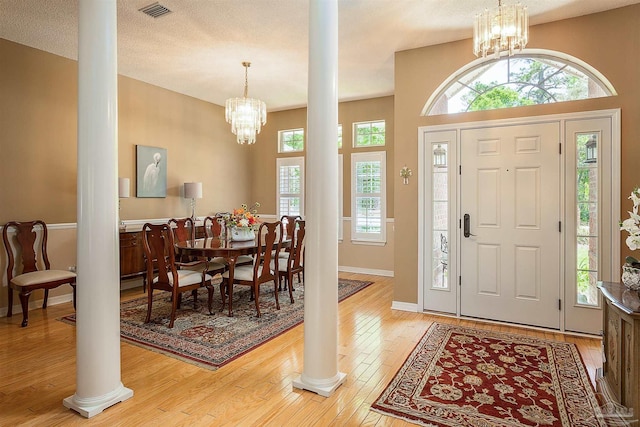 4200 Madura Rd, Gulf Breeze, FL 32563 - entrance foyer featuring ornate columns, a notable chandelier, visible vents, baseboards, and hardwood / wood-style floors
