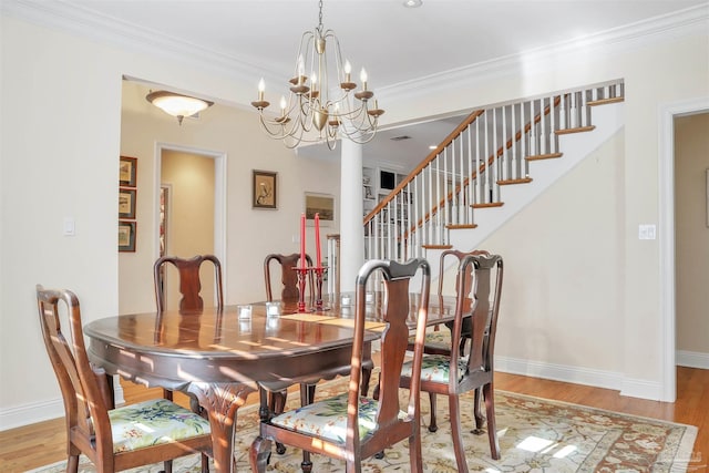 dining area with ornamental molding, a chandelier, and light wood-type flooring