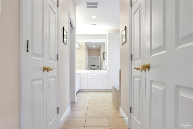 hallway with sink and light tile patterned floors