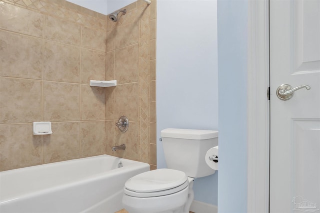 bathroom with toilet and tiled shower / bath