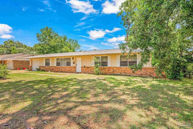 single story home with a garage, brick siding, and a front lawn