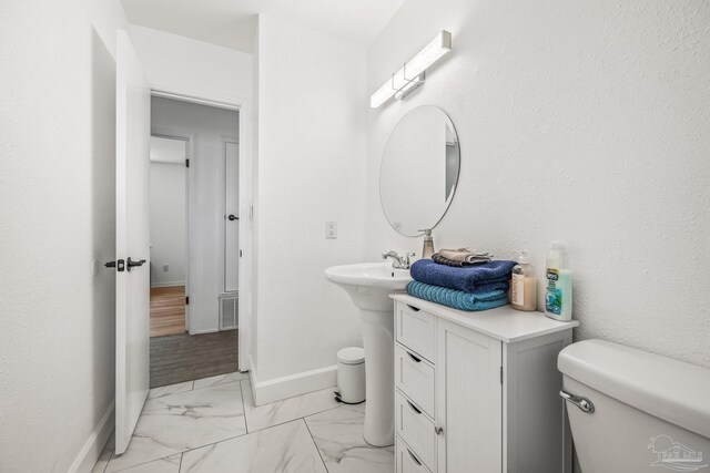 bathroom with hardwood / wood-style floors and toilet