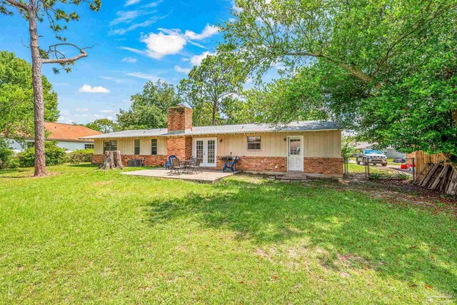 rear view of house featuring a patio and a yard