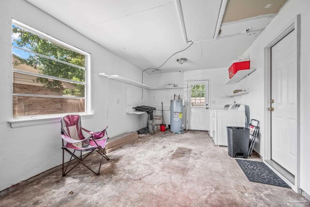 garage featuring electric water heater and washer and clothes dryer