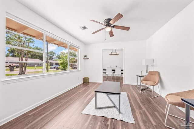 sitting room with wood-type flooring and ceiling fan