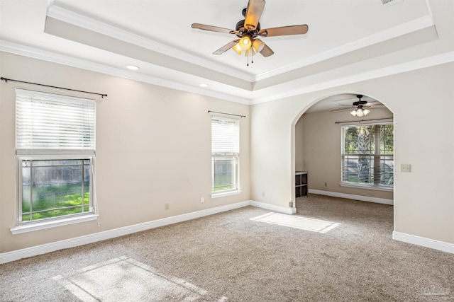 unfurnished room featuring ceiling fan, a raised ceiling, ornamental molding, and carpet