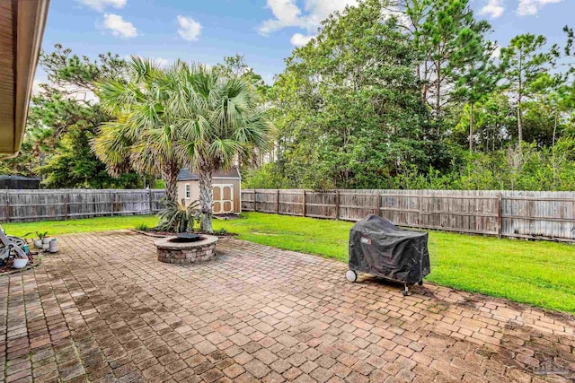 view of patio / terrace featuring grilling area, a storage unit, and an outdoor fire pit