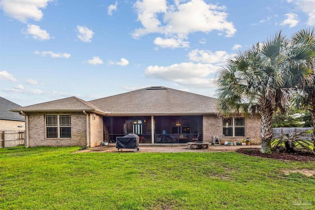 rear view of property featuring a lawn and a sunroom