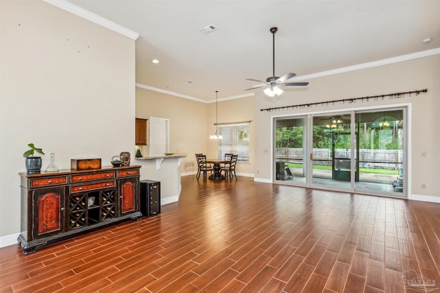 living room with wood-type flooring, ornamental molding, and ceiling fan